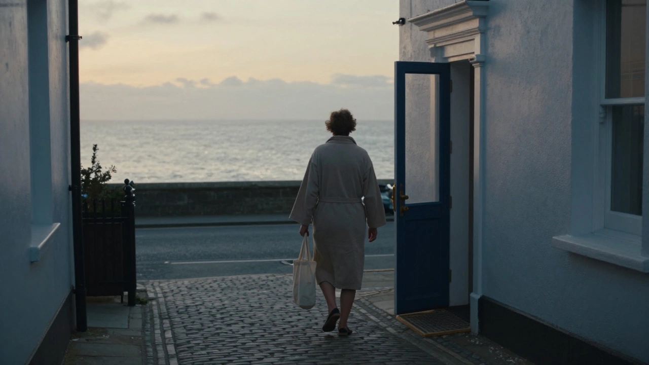 A client walking quietly toward a private massage studio at dawn, with seaside calm and no crowds in sight.